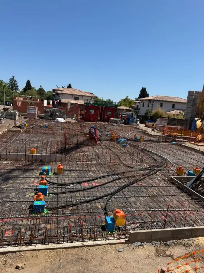 Vue du chantier de bâtiment collectif à Villenave-d'Ornon avec réseaux de plomberie incorporés avant coulage