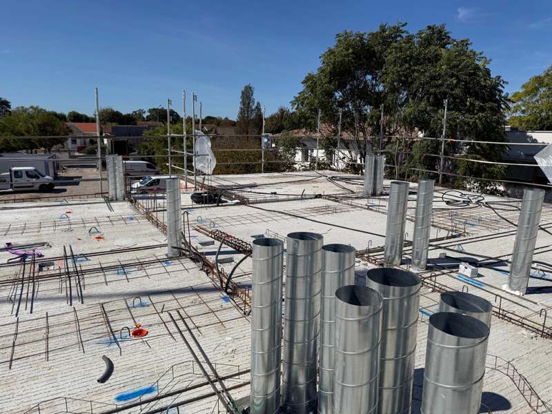 Conduits spiralés en acier galvanisé posés avant coulage sur le toit terrasse d'un bâtiment collectif à Villenave-d'Ornon