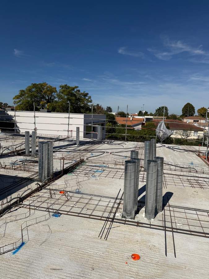 Traversées de toiture et gaines fixées au ferraillage du toit terrasse d'un immeuble neuf à Villenave-d'Ornon